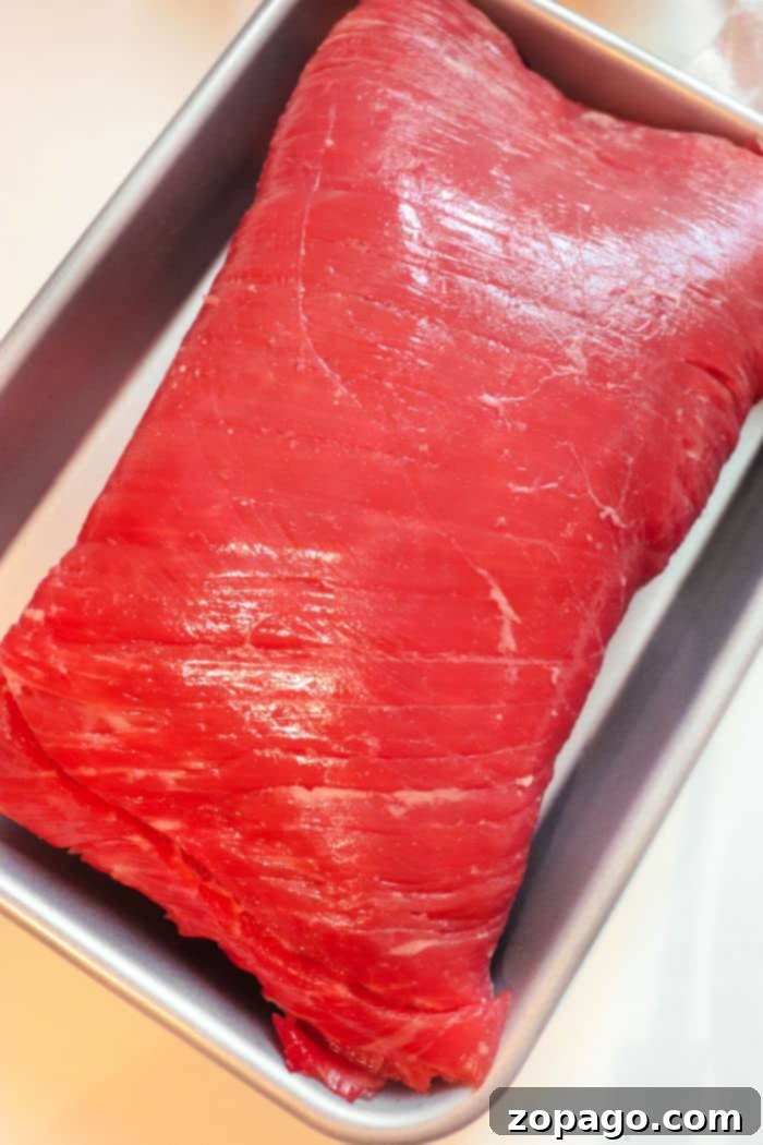 Perfectly Tender Air Fryer Brisket 4 Raw beef brisket with a prominent fat cap, expertly seasoned with a dry rub, ready to be air-fried.