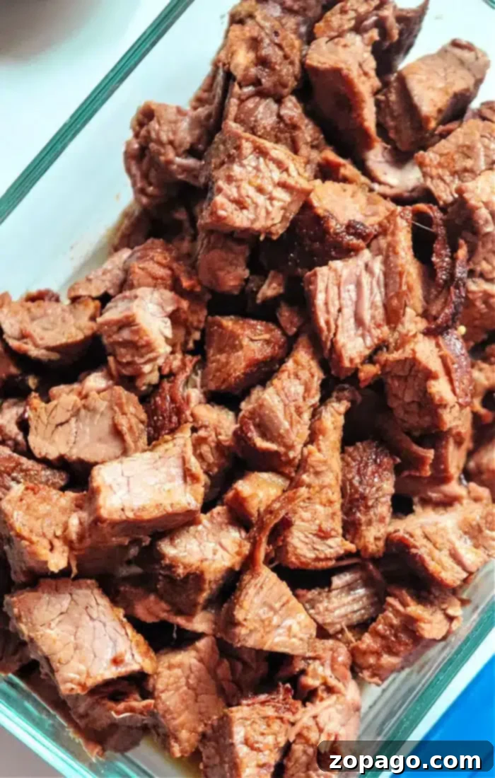 Perfectly Tender Air Fryer Brisket 7 Cubed air fryer brisket, tender and browned, presented in a clear glass container, ready for serving or incorporating into delicious leftover recipes.