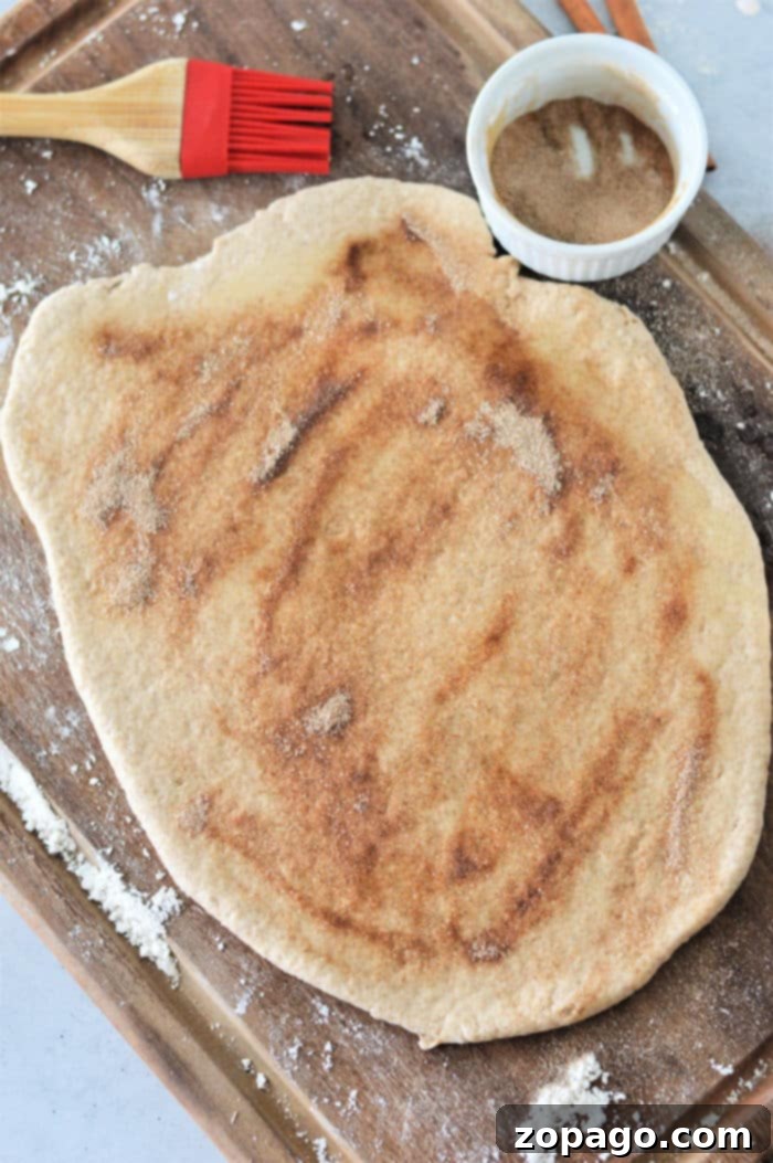 Effortless Bisquick Cinnamon Rolls 4 Bisquick cinnamon rolls with glaze in a baking pan.