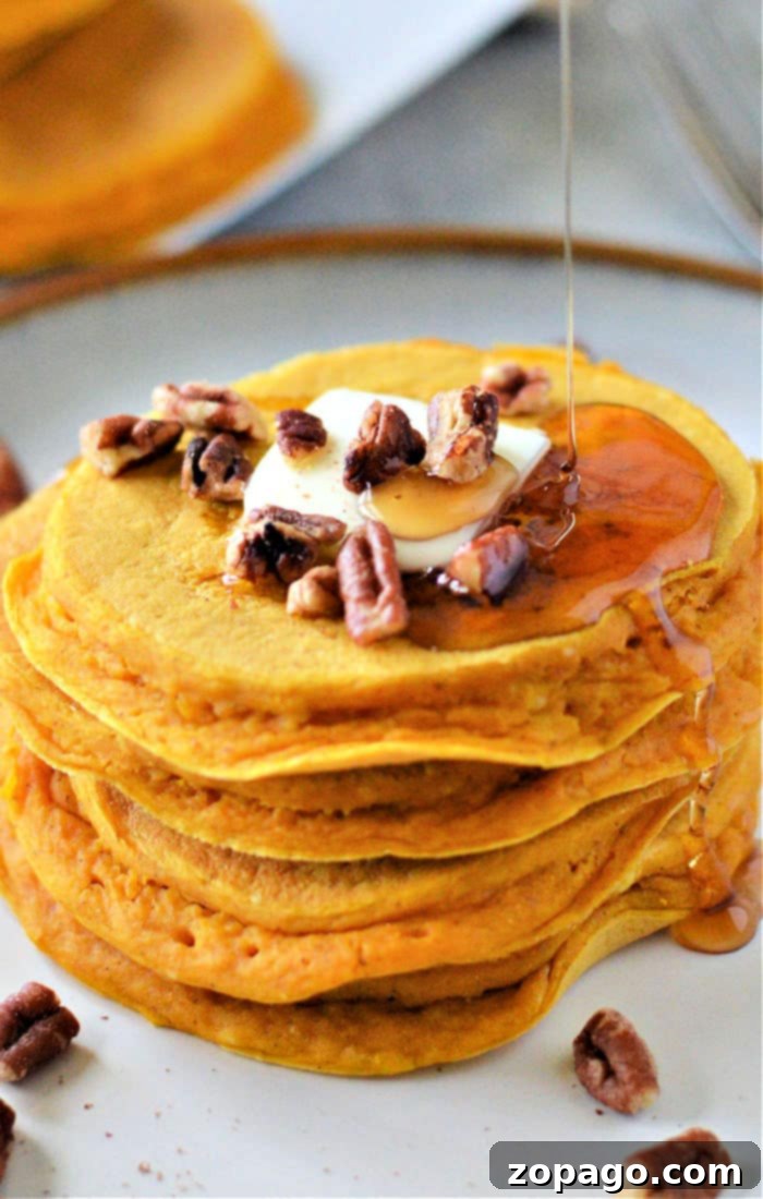 Effortless Bisquick Meals 3 A stack of pumpkin pancakes made with Bisquick, topped with butter, pecans, and a drizzle of syrup.