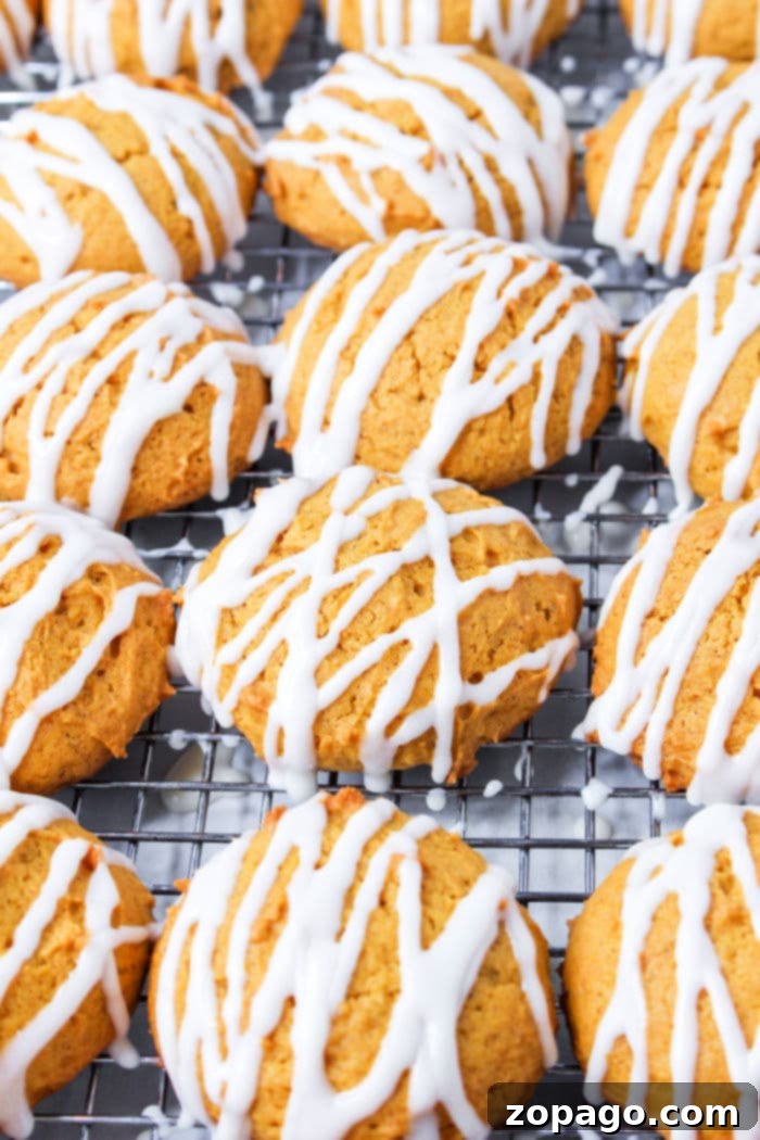 Glazed Pumpkin Spice Cookies 6 A stack of iced pumpkin cookies, glistening with cream cheese glaze, highlighting their delectable appeal.