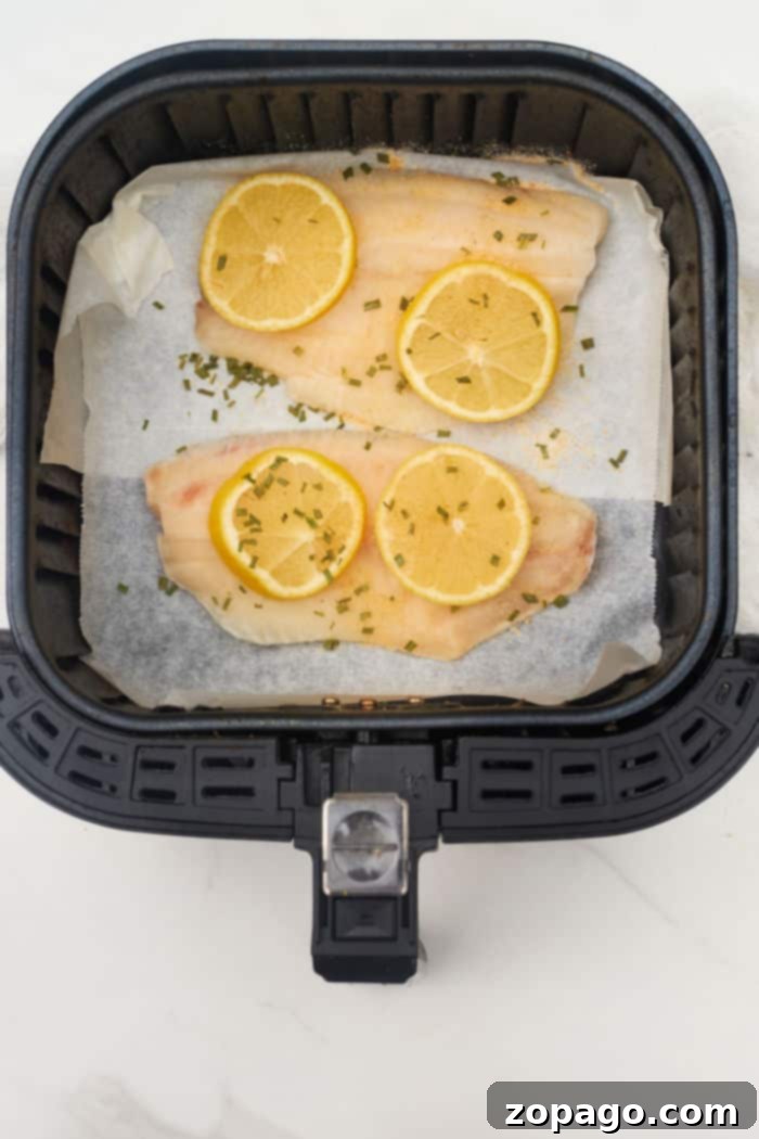 How to Cook Frozen Tilapia in Air Fryer with lemon slices and seasoning.