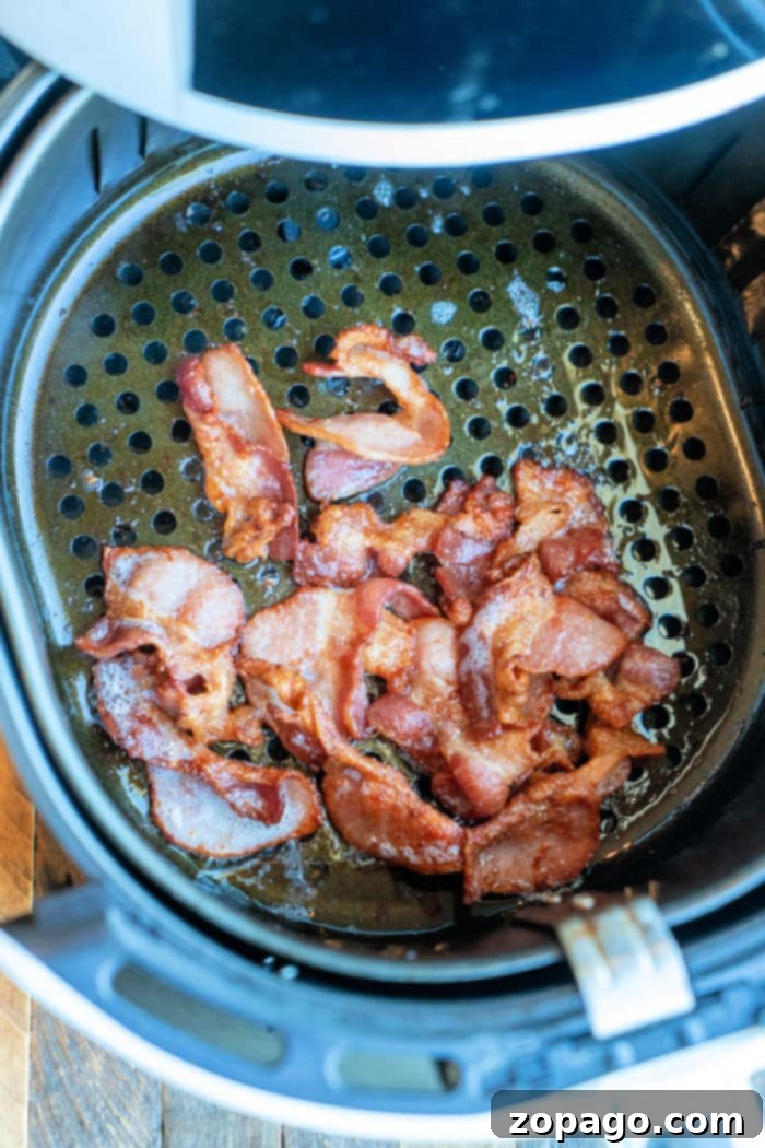Get Crispy Frozen Bacon in Your Air Fryer 6 Frozen bacon strips cooked in an air fryer, ready to be served for breakfast.