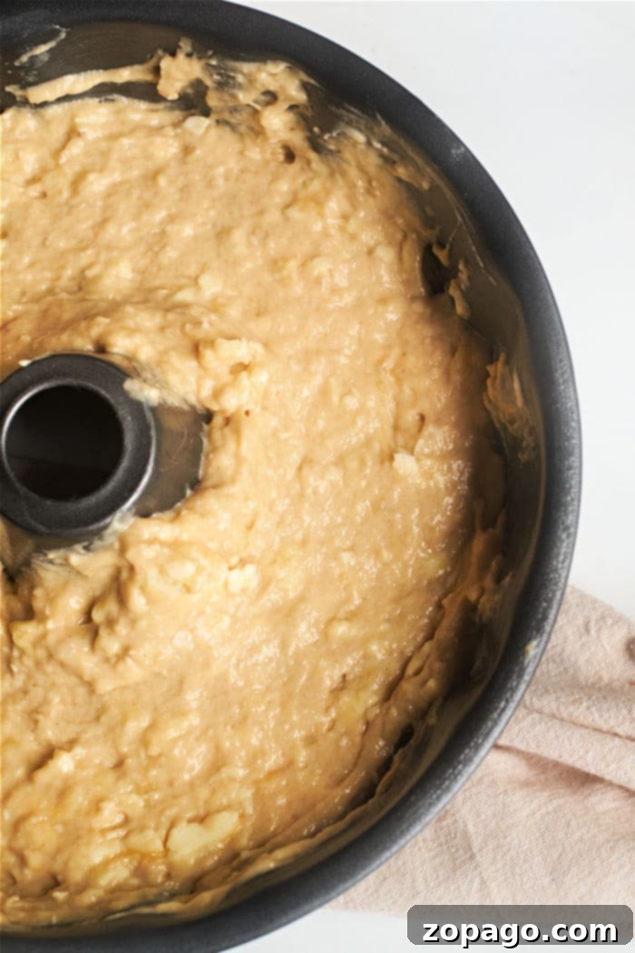Beautifully baked banana bread in a decorative bundt pan, cooling on a rack.