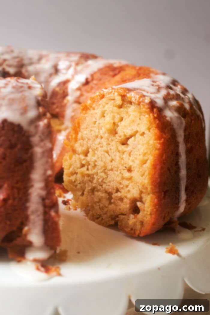 A close-up of a slice of banana bundt cake, showing its moist crumb and golden-brown crust.
