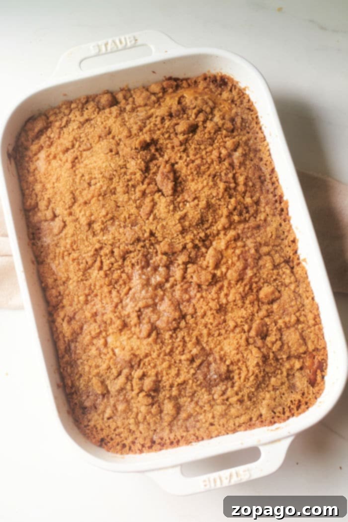 Banana Streusel Coffee Cake 2 Delicious banana coffee cake with a golden-brown streusel topping, presented on a rustic wooden board.