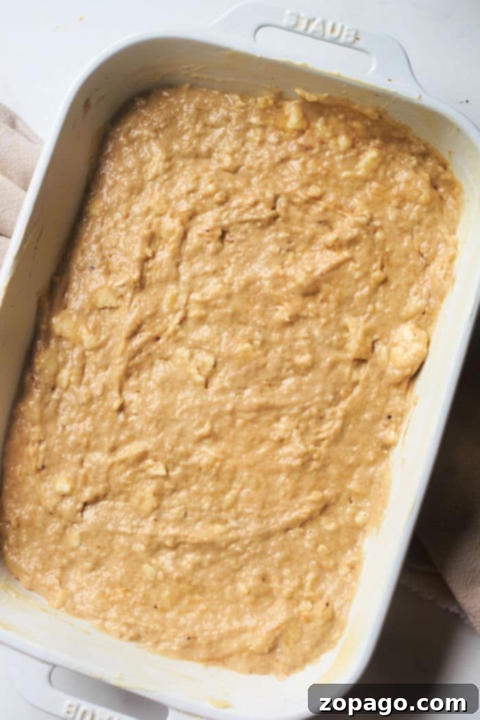 Banana Streusel Coffee Cake 4 A 9x13 inch baking dish filled with banana bread batter, topped generously with a streusel crumble, ready for the oven.