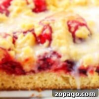 Close-up of a cake mix coffee cake with glaze, showcasing a golden crust and vibrant cherry filling reminiscent of a cherry coffee cakes rich textures and flavors.