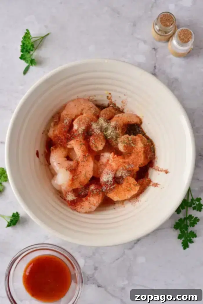 Seasoned Ninja Foodi shrimp with no breading, glistening and ready for the air fryer