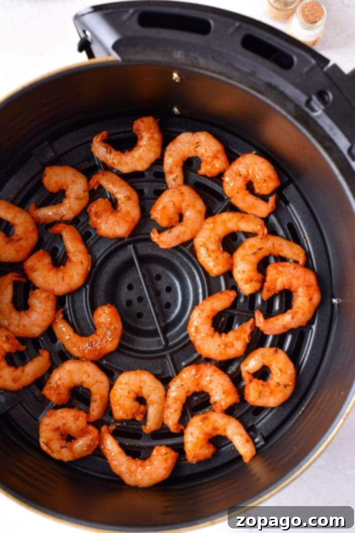 Beautifully cooked air fryer shrimp no breading, garnished with fresh parsley and a wedge of lemon.
