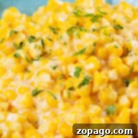 Close-up of Honey Butter Skillet Corn, creamy and garnished with chopped parsley, elegantly served in a turquoise bowl.