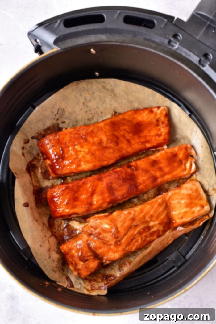 Sticky Air Fryer Teriyaki Salmon 7 Air Fry Teriyaki Salmon - garnished and ready on a plate with fresh herbs and a side of lemon.