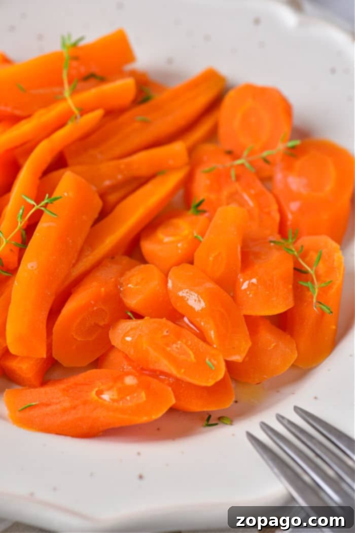 Microwave Carrots in Minutes 2 Cook Carrots in Microwave - a vibrant bowl of tender, sliced carrots garnished with fresh herbs, ready to be served.