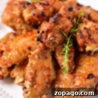 A plate of crispy Instant Pot Air Fryer chicken wings garnished with fresh herbs.