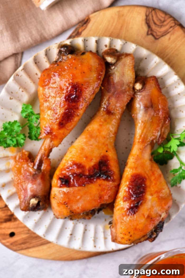 How Long to Roast Chicken Drumsticks at 400F 6 baked chicken drumsticks are artfully arranged on a plate with a fresh parsley garnish, all set atop a rustic wooden board. Wondering how long to bake chicken drumsticks at 400 degrees? These tips ensure each bite is perfectly cooked and bursting with flavor.