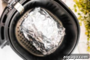 Crispy Air Fryer Corned Beef 7 A foil-wrapped Air Fryer Corned Beef sits inside the basket, ready to be cooked to perfection.