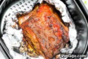 Crispy Air Fryer Corned Beef 8 Air Fryer Corned Beef rests on aluminum foil inside the air fryer basket, freshly cooked and ready to serve.