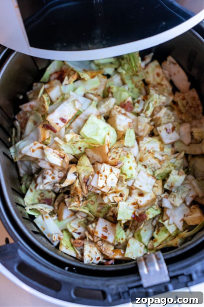 Crispy Air Fryer Cabbage 7 A large serving of golden-brown air fryer fried cabbage, generously sprinkled with crispy bacon bits, presented in a bowl for a hearty side dish.