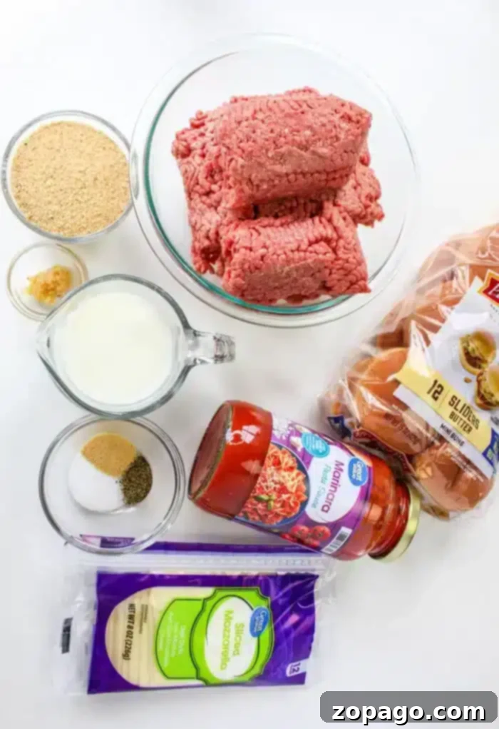 Easy Skillet Meatballs 3 On a white surface, ground beef rests beside slider buns, marinara sauce, and sliced mozzarella cheese. Accompanied by breadcrumbs and small bowls of minced garlic and seasoning, a cup of milk completes the setup for learning how to cook meatballs on the stovetop.
