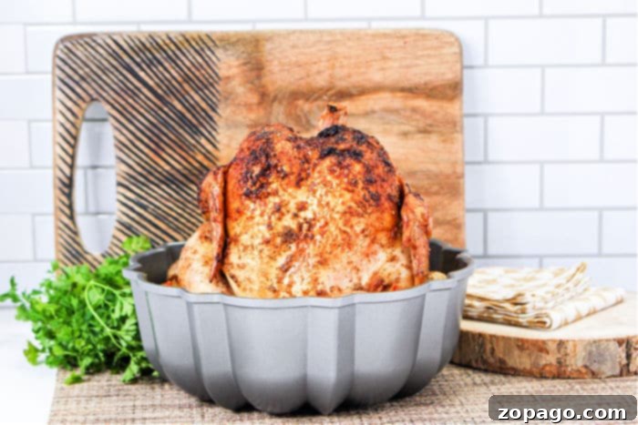 Homemade Rotisserie Style Chicken 7 Bundt Pan Chicken: A beautifully roasted whole chicken seated on a Bundt pan, showcasing its golden-brown skin and readiness for carving.