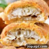 Close-up of a beer-battered, air-fried roll filled with shredded fish, shown cut in half.