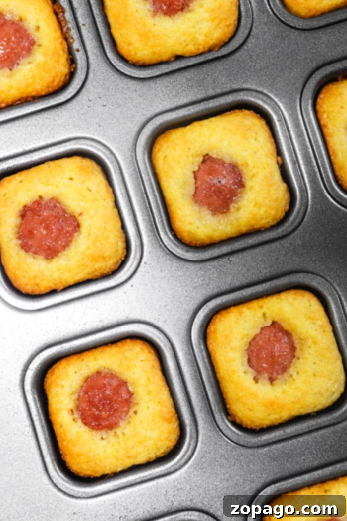 Golden Corn Dog Nuggets 7 Close-up of Jiffy Corn Dog Muffins in a regular muffin tin, showing their fluffy texture and golden tops.
