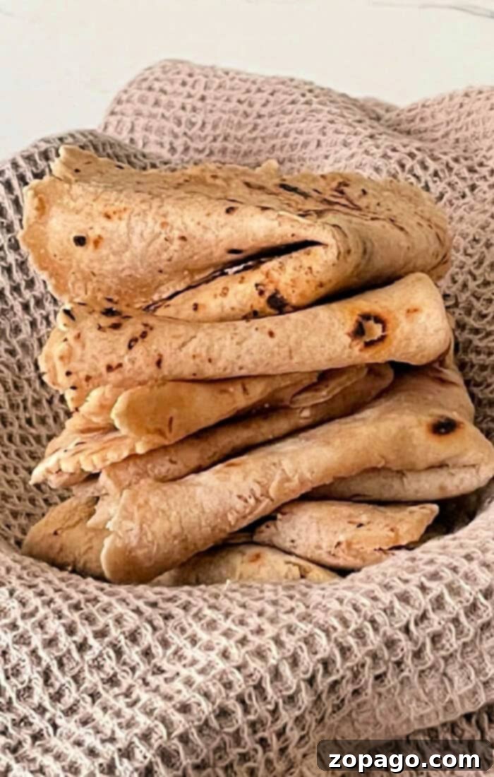 Freshly made Roti bread on a textured cloth, showcasing how to make soft, pliable Indian flatbread at home.