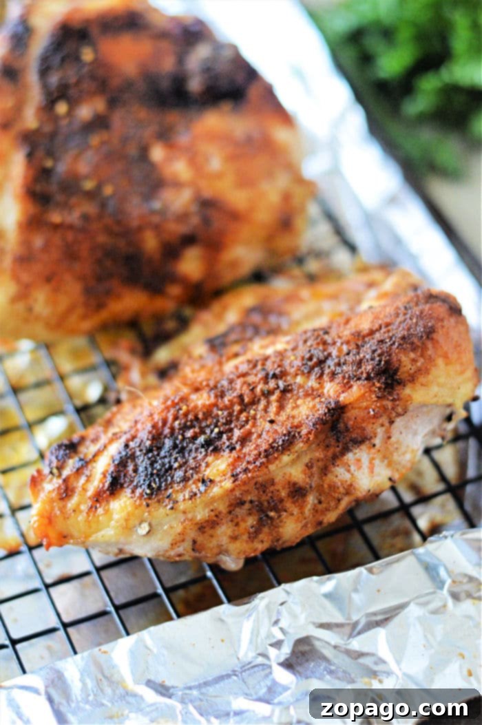 How Long to Bake Chicken Breast at 350F 2 A close-up of a perfectly seasoned baked chicken breast resting on a foil-lined rack. Ideal for those wondering how long to cook chicken breast in the oven at 350°F.