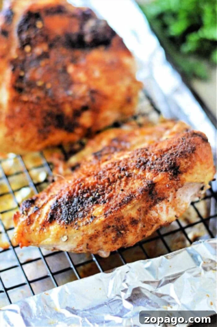 How Long to Bake Chicken Breast at 350F 10 roasted chicken breast with seasoning rests on a wire rack over foil, perfect for even cooking. Curious about oven time? Bake at 350°F for a juicy finish.