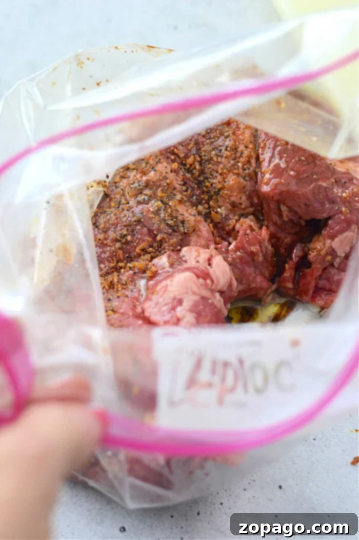 Cast Iron Seared Flank Steak 3 Flank steak with spices and marinade in a Ziploc bag, ready to be sealed before sizzling on a cast iron skillet.