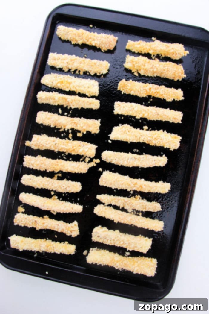 A fresh batch of golden-brown baked eggplant fries, hot and ready to be served.