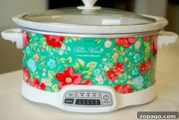 Easy Frozen Pork Chops Slow Cooker 3 A floral design slow cooker with a white base and lid sits on a kitchen countertop, perfect for whipping up a 5 ingredient crockpot chili recipe.
