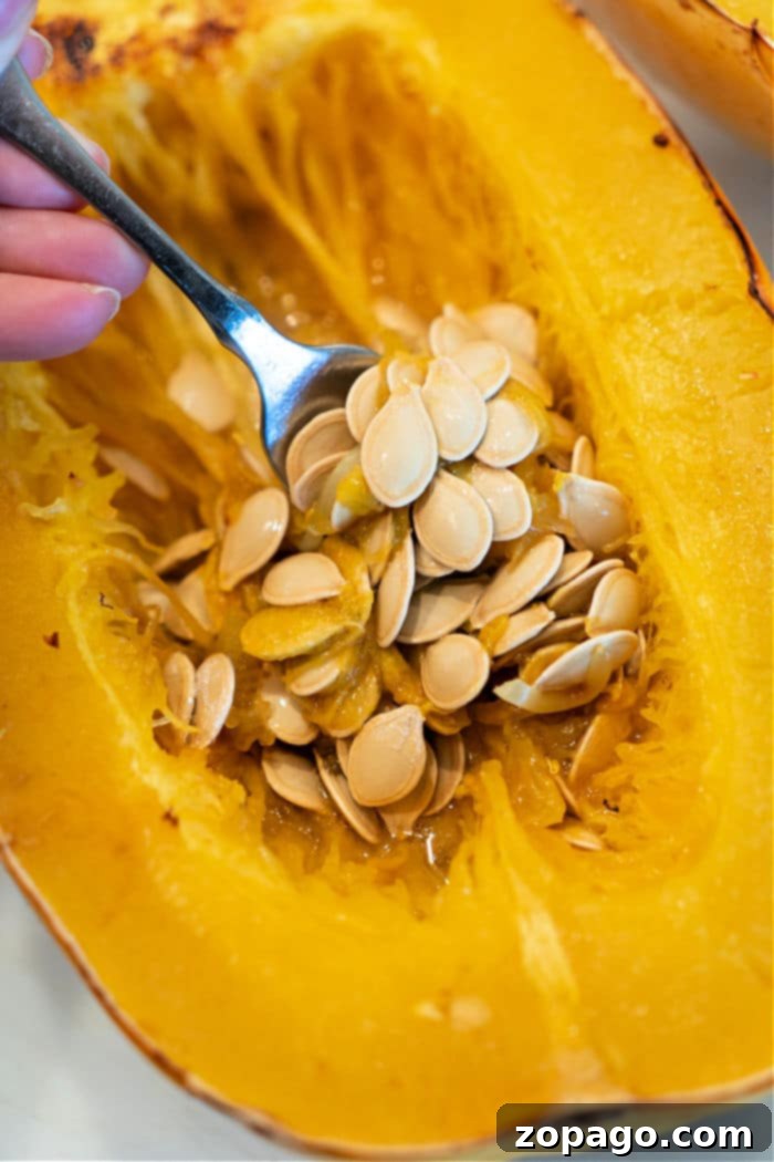 Crispy Spaghetti Squash Seeds 3 Raw spaghetti squash seeds being scooped from the squash, preparing for roasting.