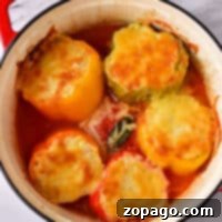 Savory Stuffed Bell Peppers 8 Baked stuffed peppers topped with melted cheese delightfully sit in a red pot on a marble surface, showcasing a perfect balance of flavors. Wondering how long to bake stuffed peppers at 400? The ideal time is about 30 minutes for that deliciously tender result.