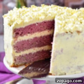 A stunning three-layer purple velvet cake, crowned with creamy white frosting and adorned with elegant white chocolate curls, takes center stage on the cake stand.