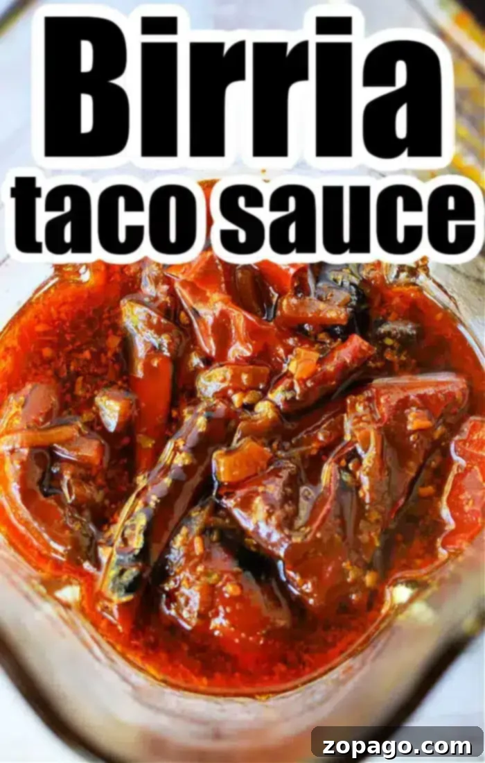 Birria Taco Sauce 5 A close-up of Birria Tacos Sauce in a glass container reveals its rich, chunky texture with visible pieces of peppers and spices. Bold lettering at the top proudly declares "Birria taco sauce.