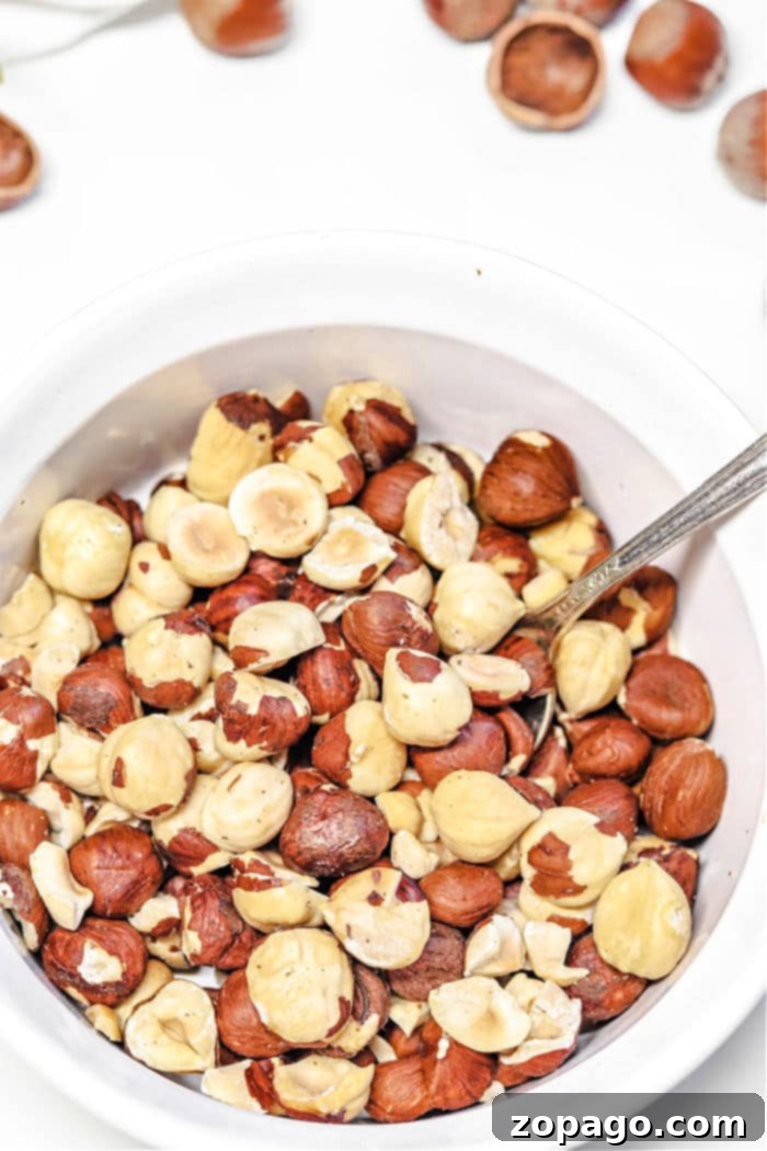 Unlock Hazelnut Flavor 6 How to Roast Hazelnuts - A wooden bowl filled with roasted hazelnuts.