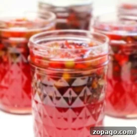 Perfect Homemade Plum Jelly with Sure Jell 6 Jars filled with red plum jelly preserves, featuring intricate patterned glass designs.