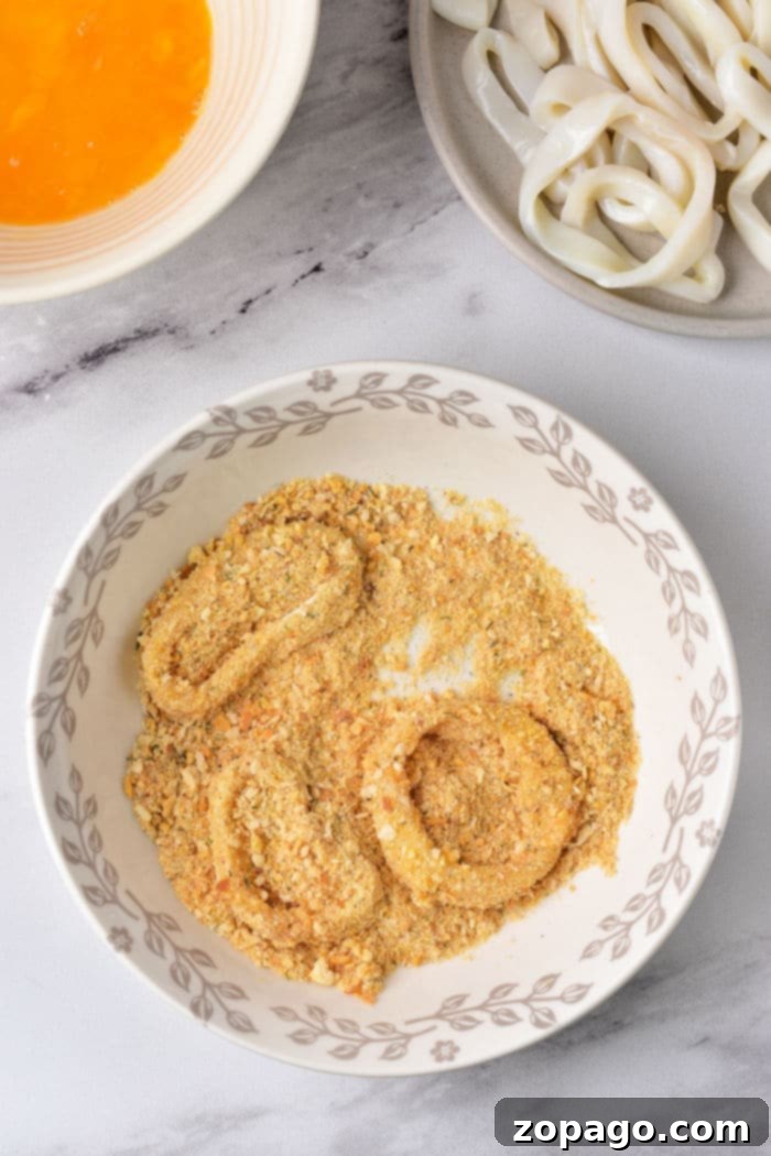 Crispy Fried Calamari 4 Crispy golden fried squid rings artfully arranged on a plate, ready to be served as an appetizer.