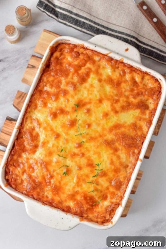 Creamy Mac and Cheese 7 Golden brown baked mac and cheese richness, nestled in a white casserole dish and crowned with fresh thyme sprigs.