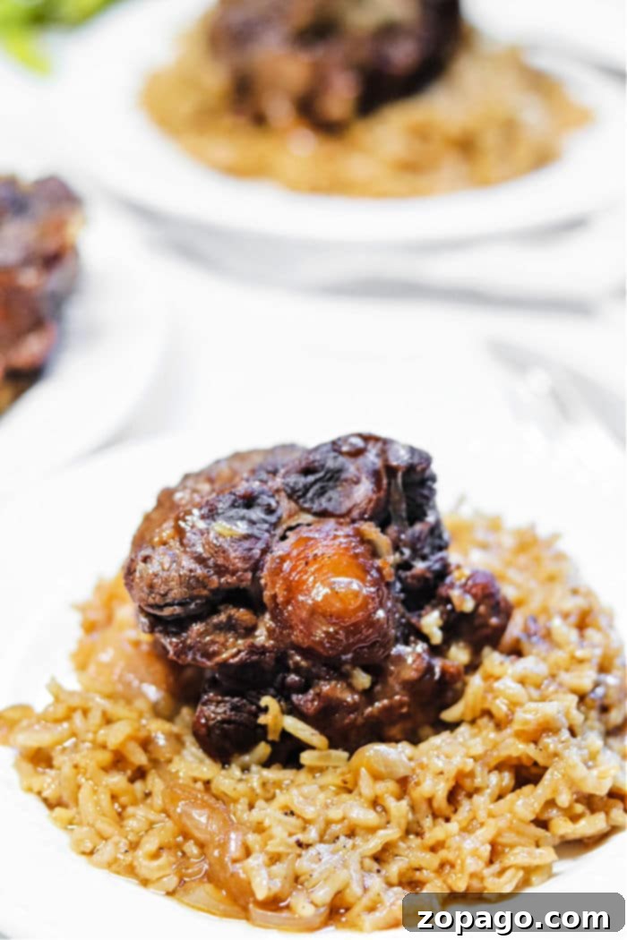 Slow-Cooked Oxtails Over Rice 6 Oxtails Rice and Peas served in a bowl