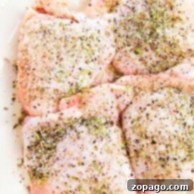 Pan-Seared Chicken Thighs 5 Raw chicken thighs seasoned with herbs and spices are neatly arranged on a white plate, ready to be transformed. Wondering how long to cook chicken thighs on the stove? Just a sizzle in the pan will bring these flavors to life perfectly.