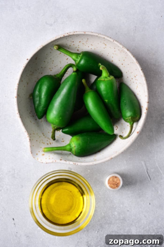 Oven-Roasted Jalapeños 3 Whole green jalapenos being prepared for roasting, showcasing their vibrant color before cooking.