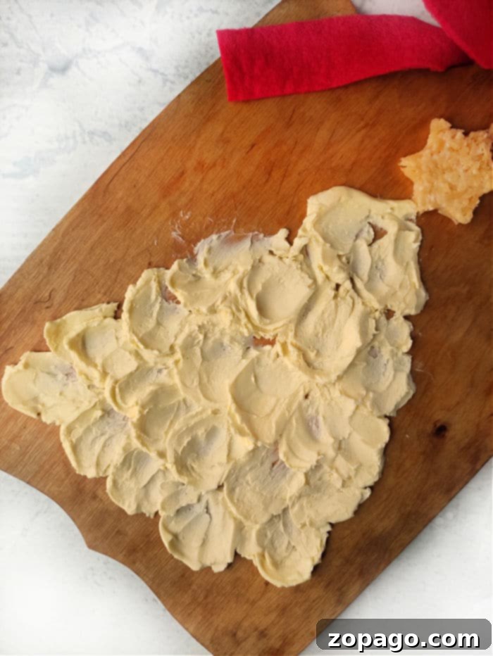 Creating a Delicious Christmas Butter Board 5 A festive Christmas tree-shaped butter spread adorns a wooden board, complete with a cheese star perched on top. Perfect for any holiday gathering, this creation elevates the traditional concept of a Christmas butter board into something truly special and delightful.