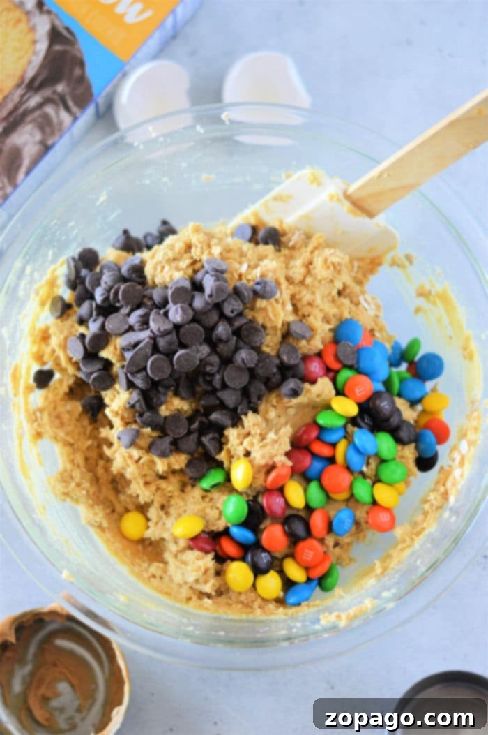 Sheet Pan Cake Mix Cookies 5 Close-up of vibrant Monster Cookie Bars, showing the rich blend of chocolate chips, peanut butter, and colorful M&M candies in each slice.