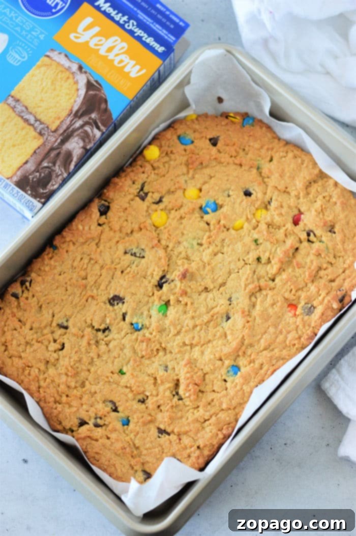 Sheet Pan Cake Mix Cookies 6 Colorful M&M Cookie Bars, freshly baked and cut into perfect squares, showcasing the generous amount of candies within.