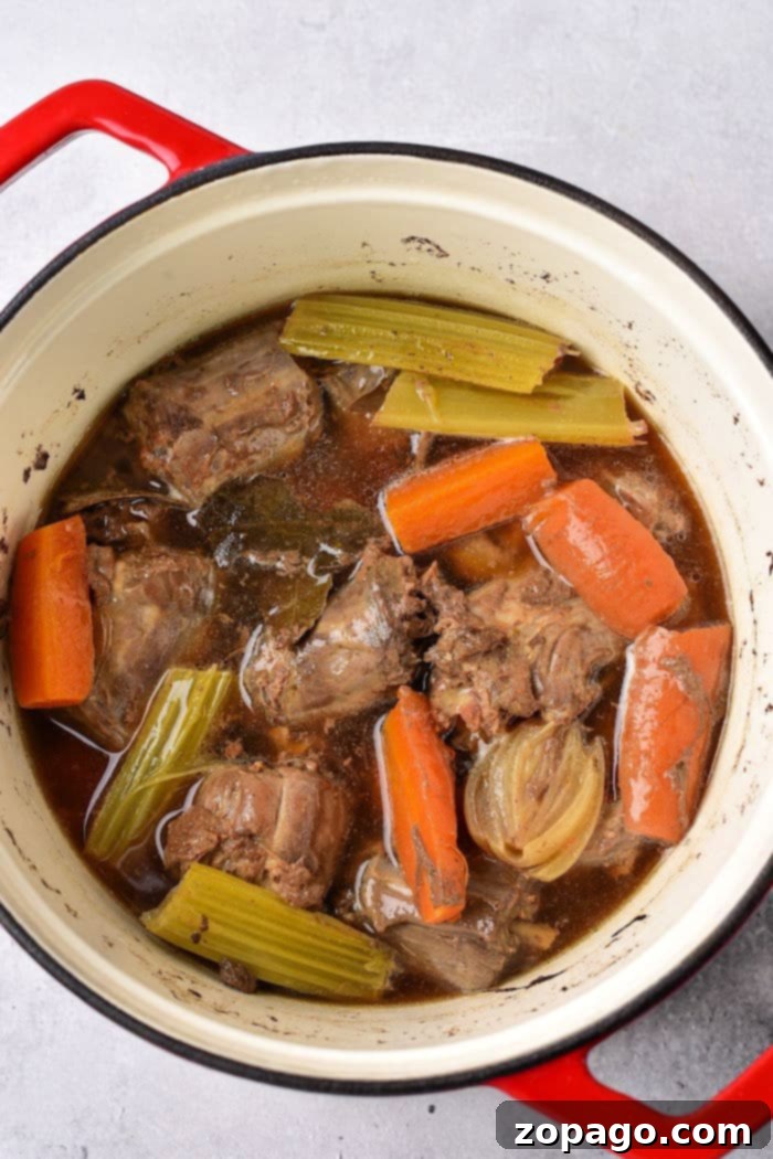 Tender Boiled Turkey Necks 4 Braised turkey necks with carrots, celery, and onions in a savory broth, ready to be enjoyed