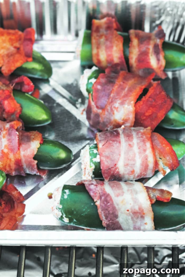 Delicious Smoked Jalapeno Poppers at 350 5 Batch of Smoked Jalapeno Poppers in an aluminum pan on a smoker grate.