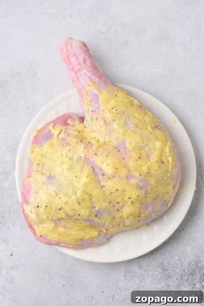 Succulent Turkey Leg Quarters 3 A raw turkey leg quarter, seasoned and ready for cooking, sits on a cutting board, emphasizing the quality of the dark meat.