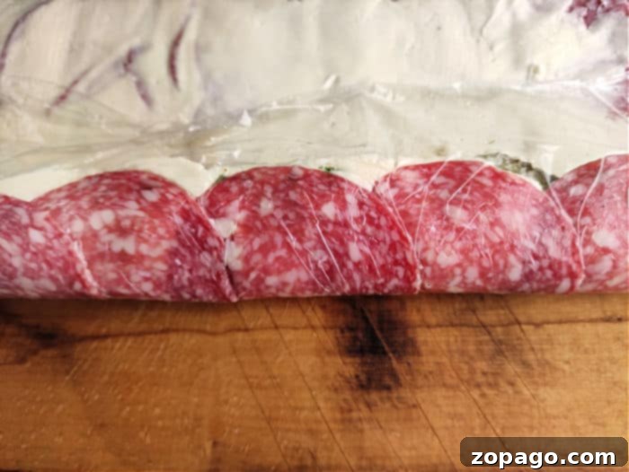 Salami-Wrapped Pickles 7 Pickle Pinwheels - A platter of salami dill pickle pinwheels with toothpicks, ready for serving.
